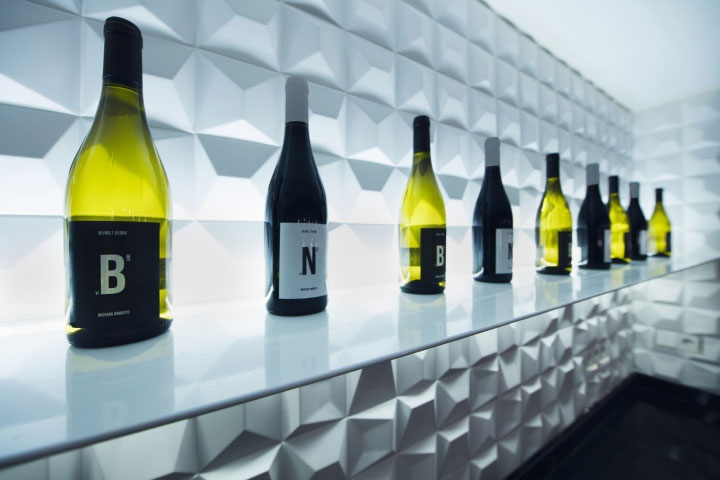 Wine display against wall with textured tiles