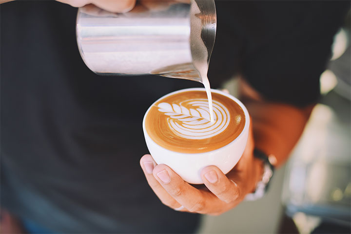 Man making an espresso topped with cream