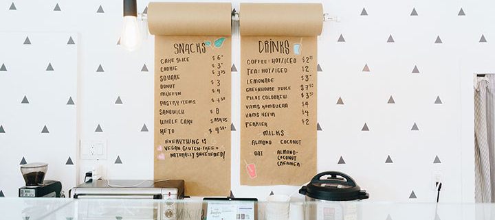 Wall-mounted paper-roll menu in a small coffee shop