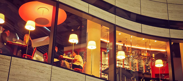 Illuminated restaurant seen from outside through the windows