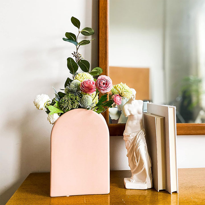 Peach-colored vase filled with flowers