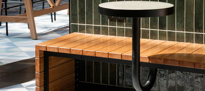Wood slat wall bench idea for a contemporary restaurant with natural vibes