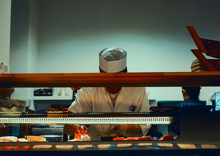 Chef in an open kitchen illustrating one of the latest restaurant interior trends.