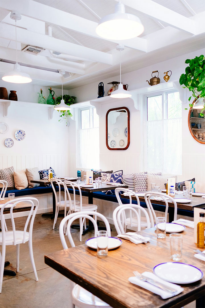 Well-lit restaurant with white walls and furniture.