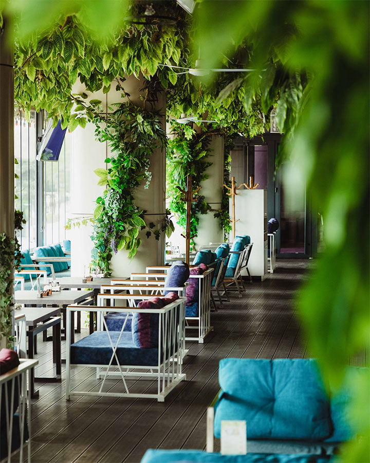 Charming restaurant with hardwod floors and lush vegetation.
