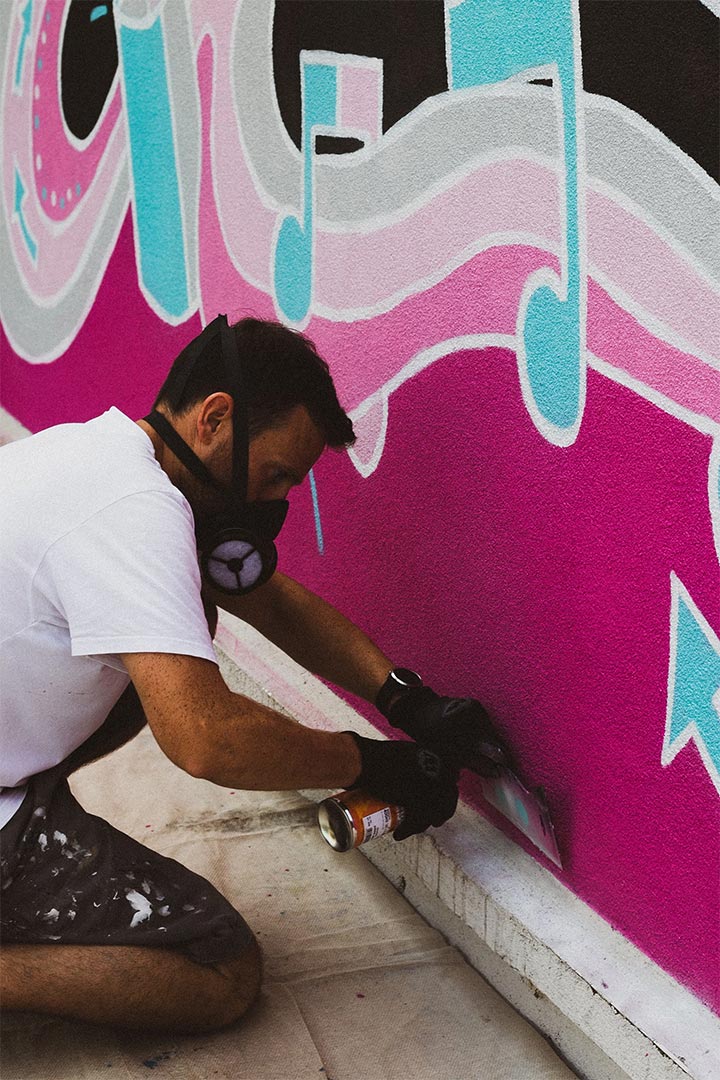 Artist painting a wall and reinforcing a brand through interior design and customized art.