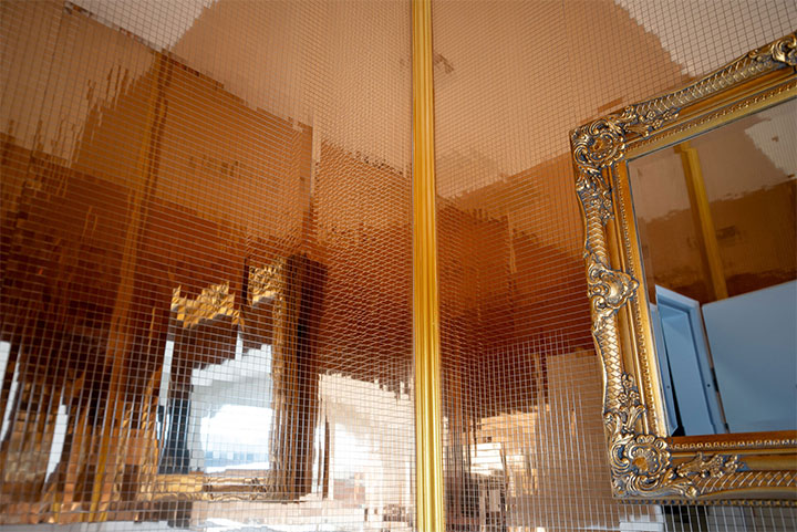 Bathroom with walls covered in gold disco-vibe decorative panels. 