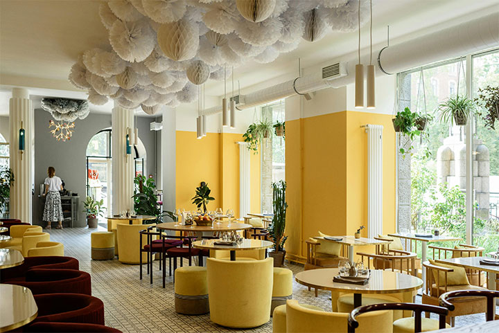 Bright yellow furniture and walls in elegant restaurant.
