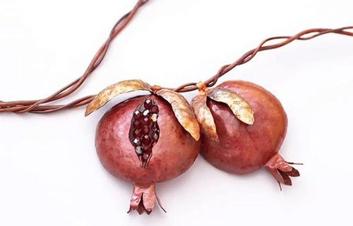 Copper wall hanging in the shape of a pomegranate branch.