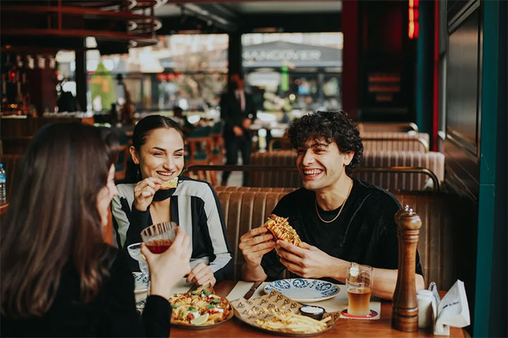 Stock imgae of young people laughing in a restaurant.