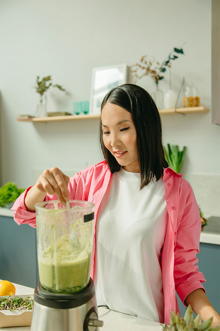 Image of a young women making a smoothie.