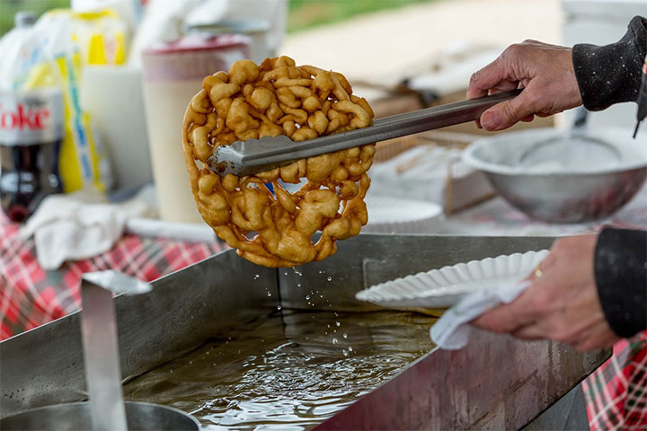 Man cooking a funnel cake.