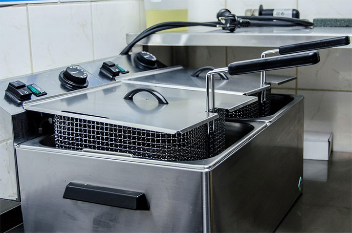Splash guard on top of a deep fryer.