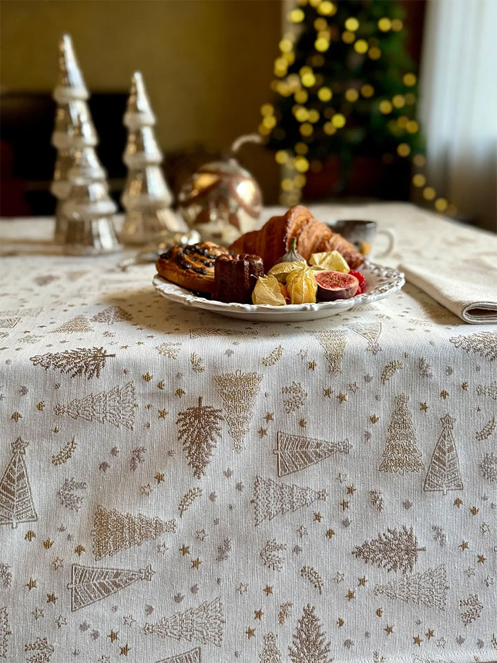 Neutral-color Christmas tablecloth with golden-tree pattern.